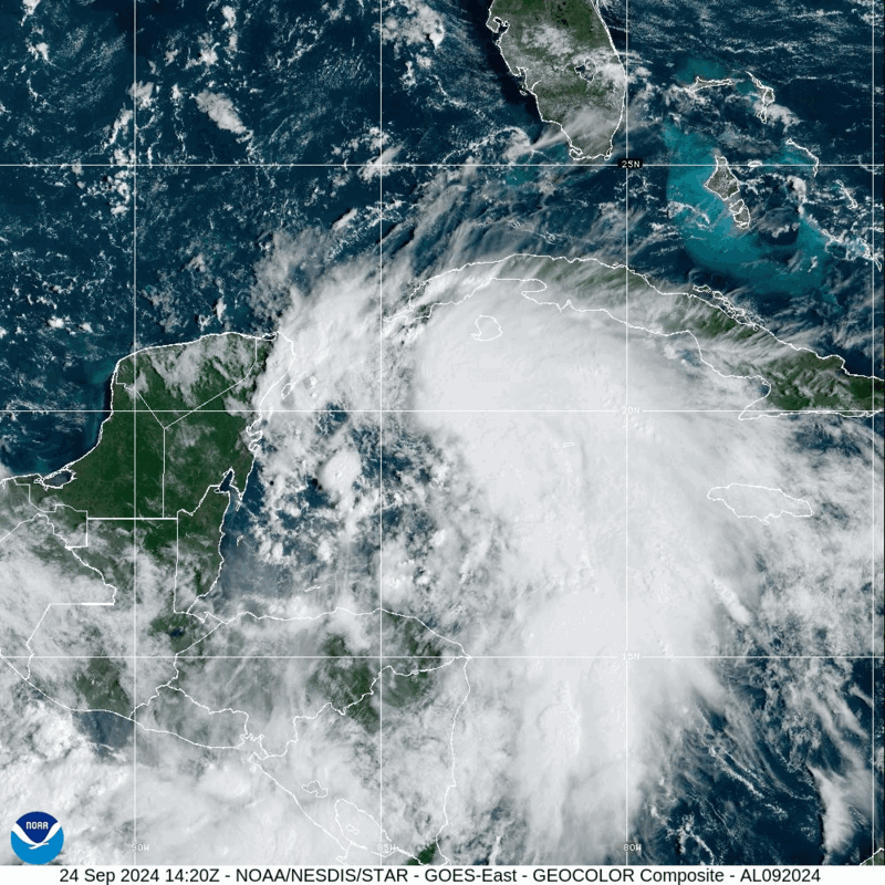 A satellite image of a well-defined, swirling cloud structure moving across the Caribbean Sea near Central America.