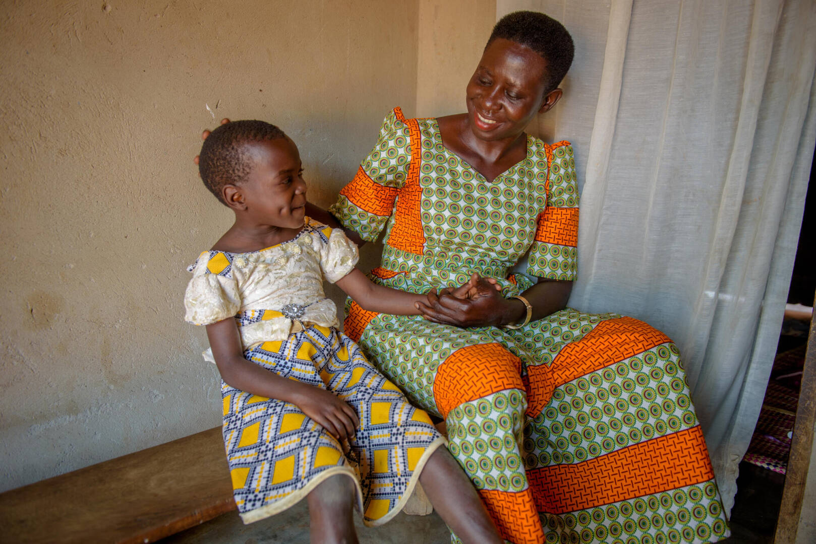 Rebecca holds her granddaughter&rsquo;s hand as they sit next to each other.