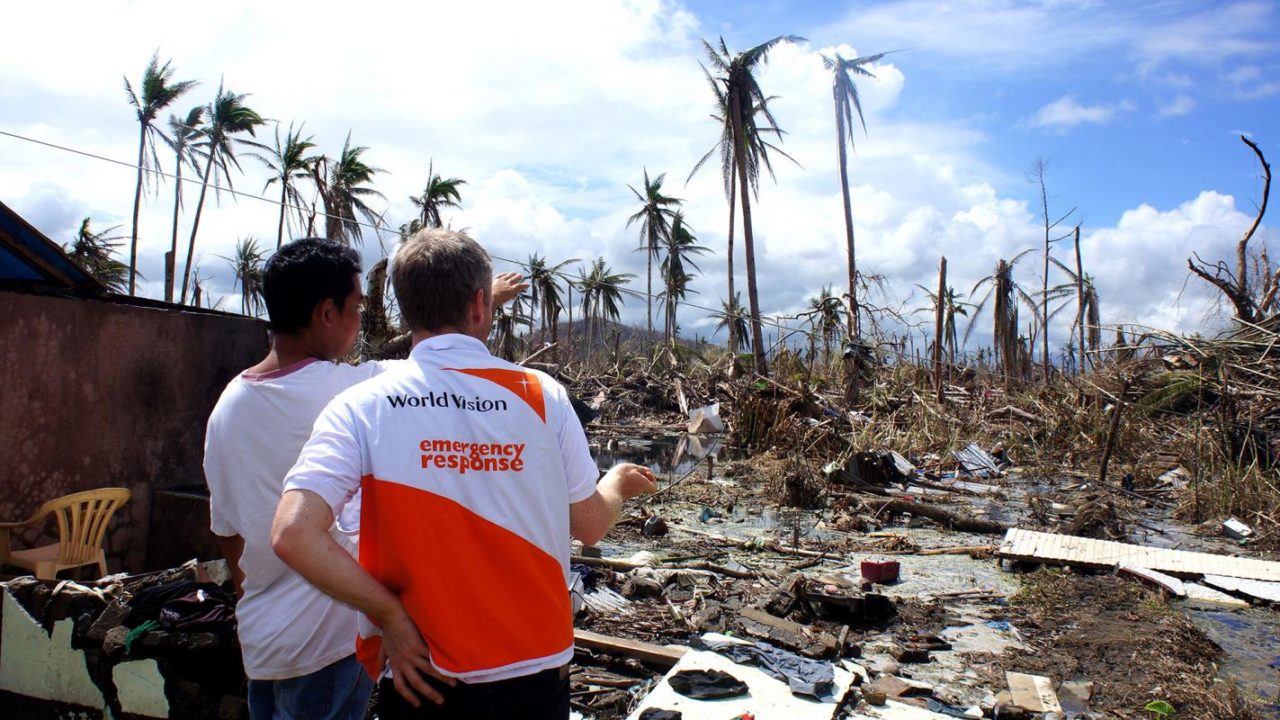 Men assess the damage of Typhoon Haiyan in 2013.