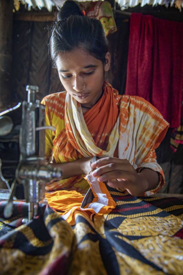 Choity, 15, makes a dress using the sewing machine she received through an ELO child protection program in Bangladesh. She dropped out of school at age 13 to help support her family. The program helped children who were working return to school, or for those far behind like Choity, it provided life-skills training for safe work.