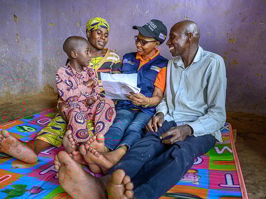 two people reading paperwork to a woman and her child