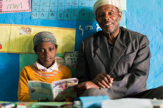 In Ethiopia, Seble and her grandfather share a book in the reading corner they made together. (&copy;2015 World Vision, Max Greenstein)