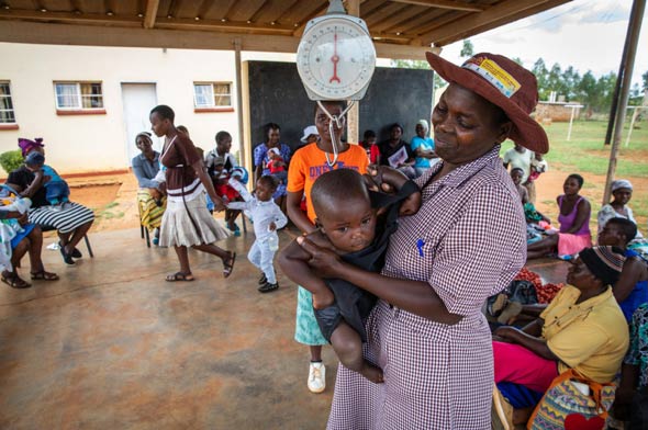 A woman weighs a baby in Zimbabwe.