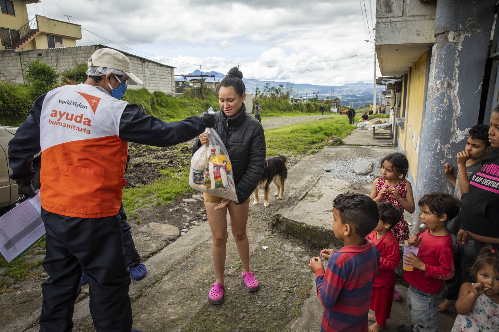 A World Vision staff member in Ecuador provides food aid to Kassandra, a Venezuelan refugee and mother of six. Her family has struggled to have enough food because her husband, who works as a street vendor, cannot go to work because of the COVID-19 pandemic.
