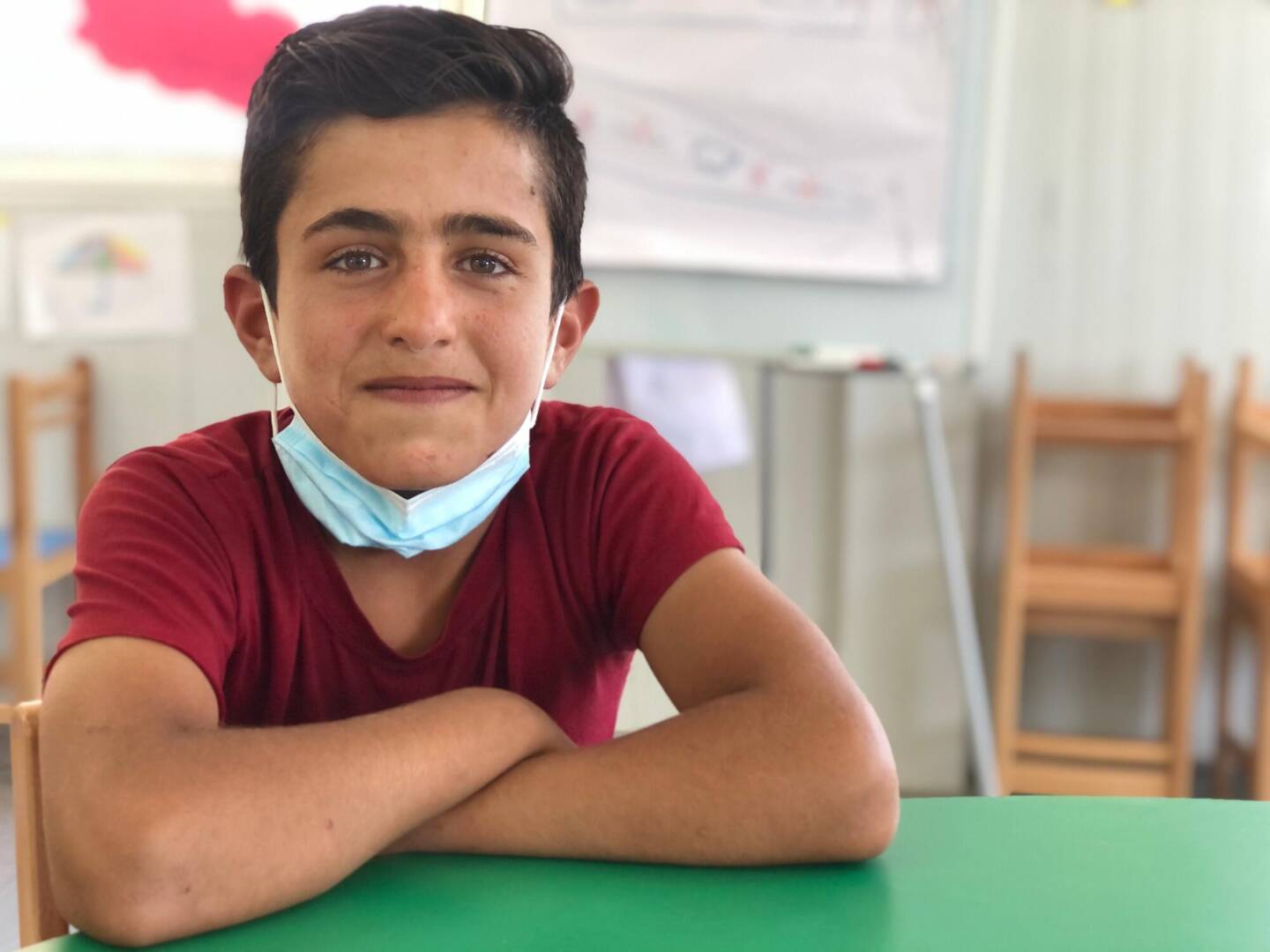 Wael, a Syrian boy, crosses his arms on the table at World Vision&rsquo;s Child-Friendly Space, where he learns about his rights as a child.