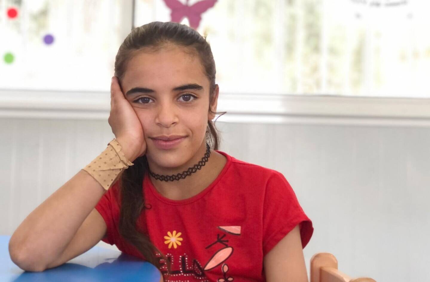 Khaula, a Syrian girl, sits in World Vision&rsquo;s Child-Friendly Space, where she learns about her rights as a child.